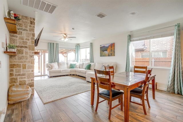 dining space featuring light wood-type flooring, visible vents, and a ceiling fan