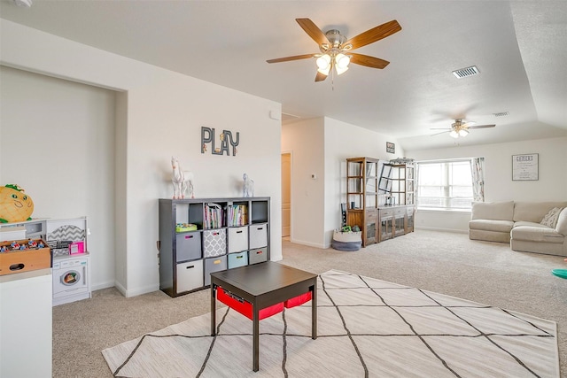 living room with baseboards, a ceiling fan, visible vents, and light carpet