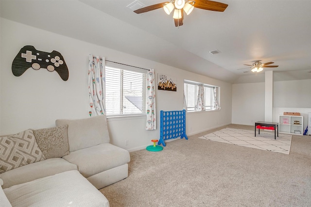 carpeted living area featuring vaulted ceiling, baseboards, visible vents, and ceiling fan