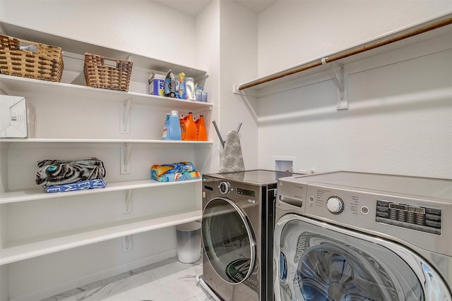 laundry area with laundry area, separate washer and dryer, and marble finish floor