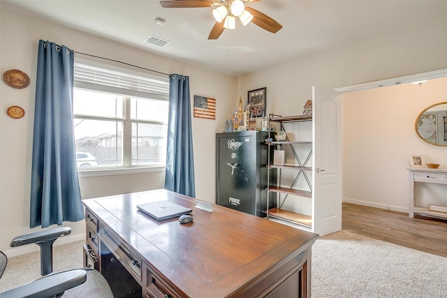 home office with visible vents, light wood-style flooring, baseboards, and a ceiling fan