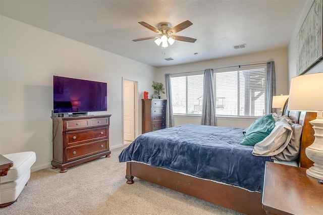 bedroom featuring a ceiling fan, baseboards, visible vents, and light carpet