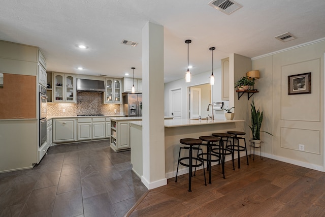 kitchen featuring visible vents, stainless steel appliances, and wall chimney exhaust hood