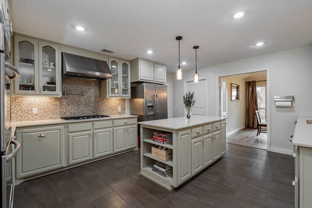 kitchen featuring visible vents, stainless steel refrigerator with ice dispenser, gas cooktop, tasteful backsplash, and wall chimney exhaust hood