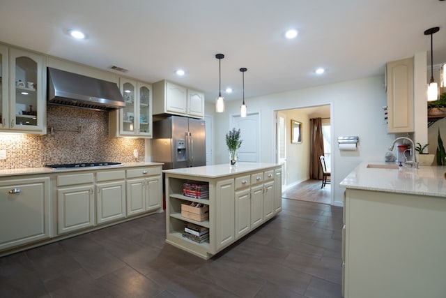 kitchen with stainless steel fridge with ice dispenser, a sink, cooktop, wall chimney range hood, and tasteful backsplash