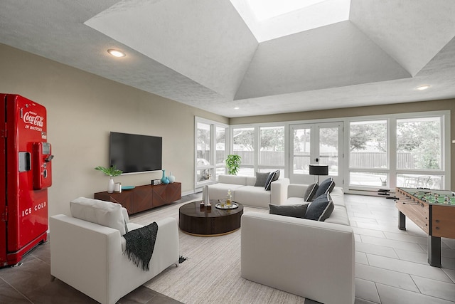 tiled living area featuring plenty of natural light, recessed lighting, a tray ceiling, and vaulted ceiling