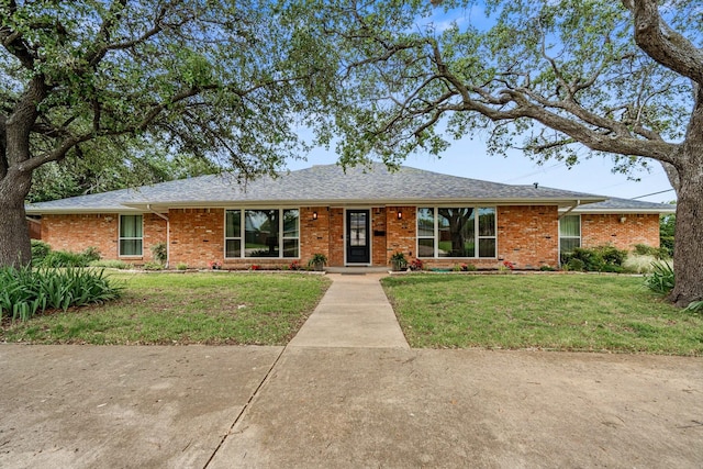 single story home featuring a front lawn, brick siding, and roof with shingles