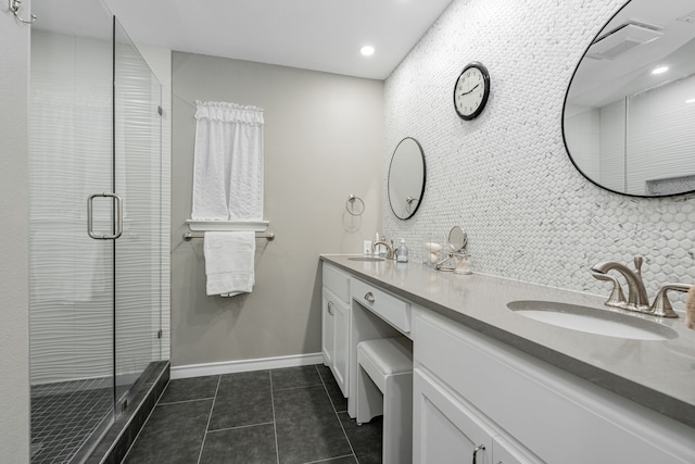 bathroom featuring a sink, a shower stall, tile patterned floors, and double vanity