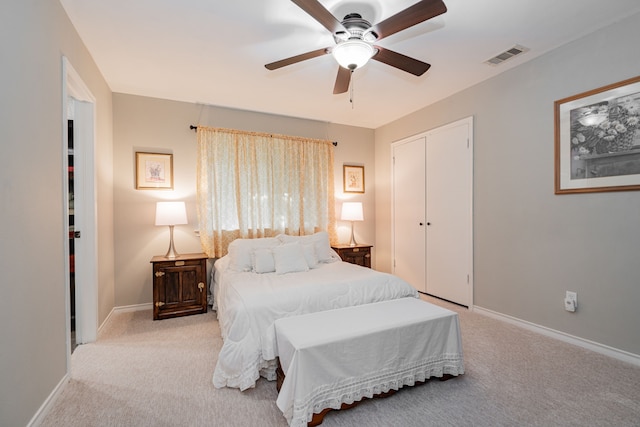 carpeted bedroom featuring a closet, visible vents, ceiling fan, and baseboards