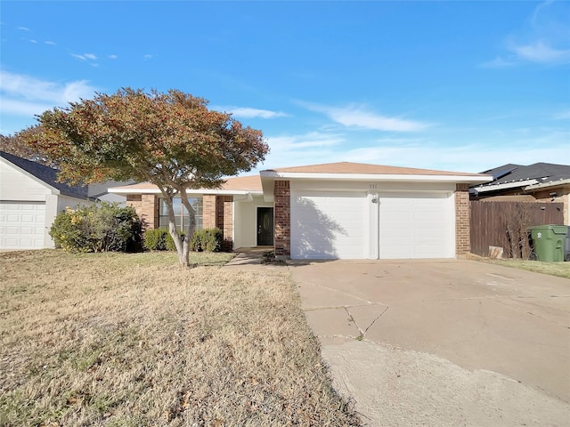 ranch-style home featuring concrete driveway, a garage, brick siding, and a front lawn