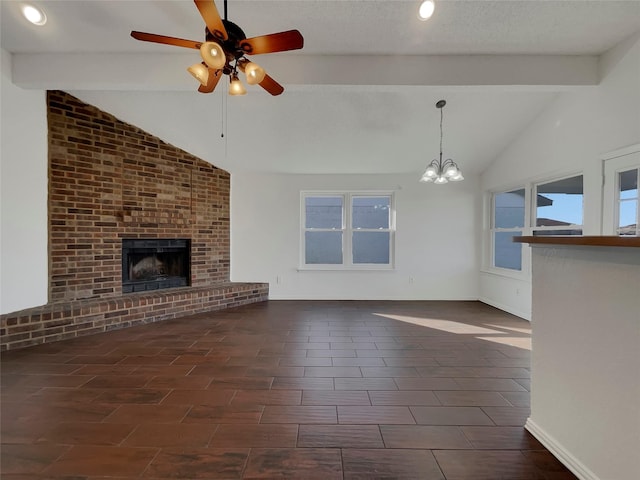 unfurnished living room featuring baseboards, lofted ceiling with beams, a textured ceiling, a brick fireplace, and ceiling fan with notable chandelier