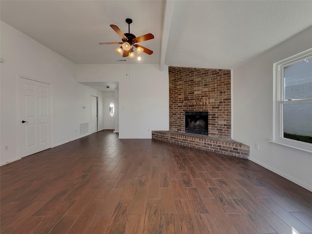 unfurnished living room featuring a ceiling fan, visible vents, dark wood finished floors, vaulted ceiling with beams, and a fireplace