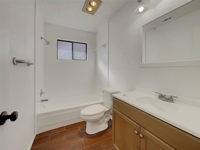 full bath with wood tiled floor, toilet, shower / bathtub combination, a textured ceiling, and vanity