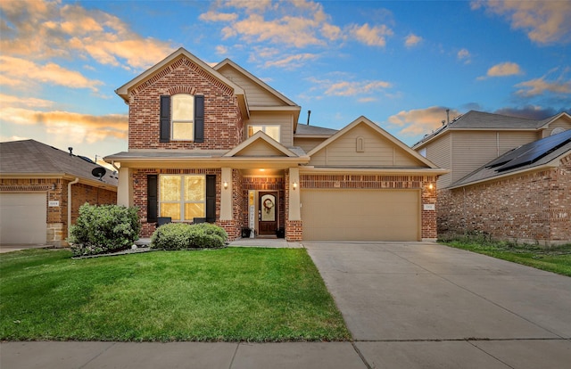 traditional-style home featuring brick siding, a yard, driveway, and a garage