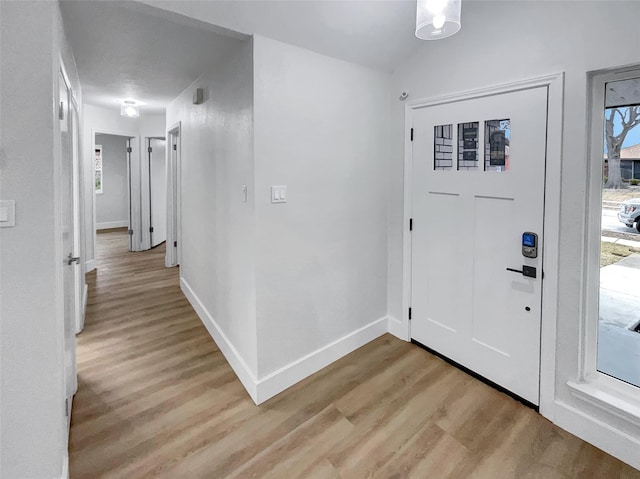 foyer entrance featuring baseboards and light wood finished floors