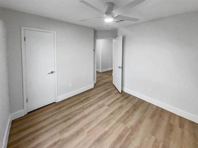 unfurnished bedroom featuring visible vents, wood finished floors, baseboards, and ceiling fan