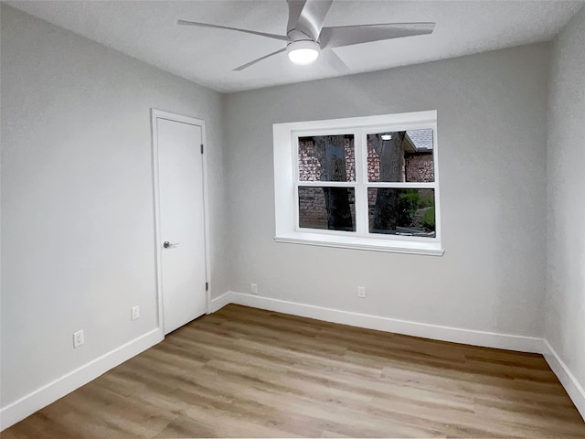 empty room featuring a ceiling fan, wood finished floors, and baseboards