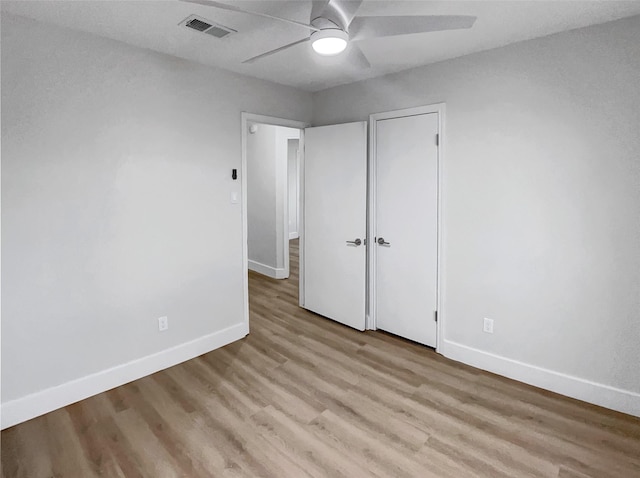 unfurnished bedroom featuring light wood-style flooring, baseboards, visible vents, and ceiling fan