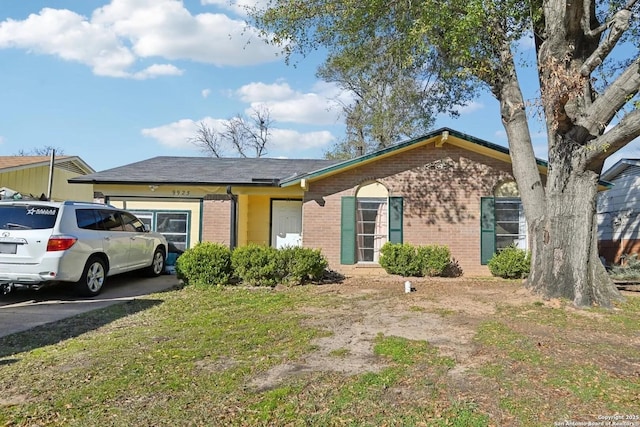 ranch-style house with driveway, brick siding, and an attached garage