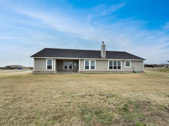 back of property featuring a lawn and a chimney