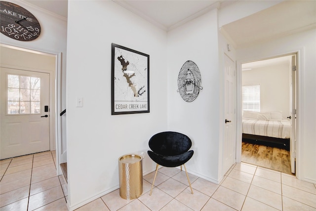 entrance foyer with light tile patterned floors, baseboards, and ornamental molding