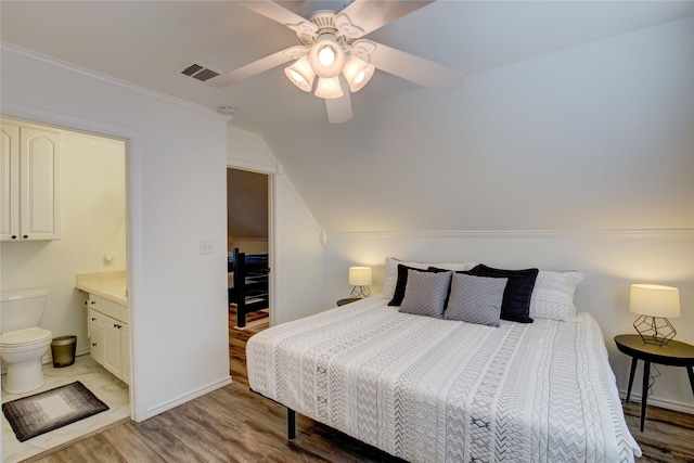 bedroom featuring lofted ceiling, crown molding, light wood-style floors, and ceiling fan