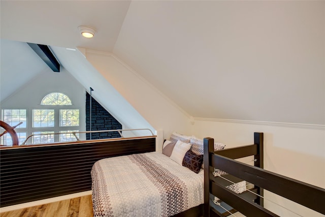 bedroom featuring vaulted ceiling with beams and wood finished floors