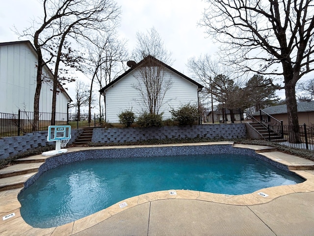 view of swimming pool featuring stairway, a fenced in pool, and fence