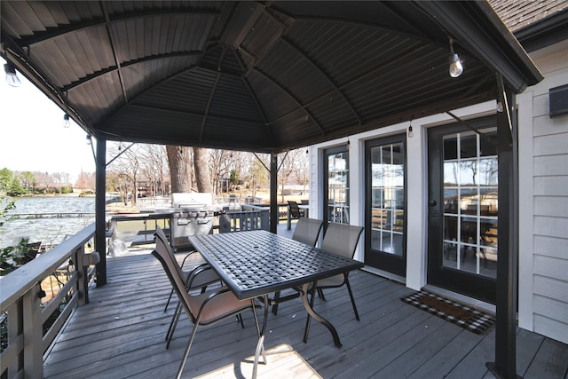 wooden terrace featuring outdoor dining space and a grill