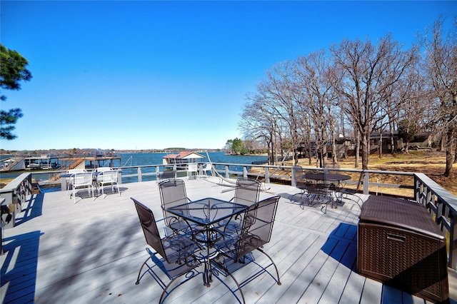 wooden deck with outdoor dining space and a water view