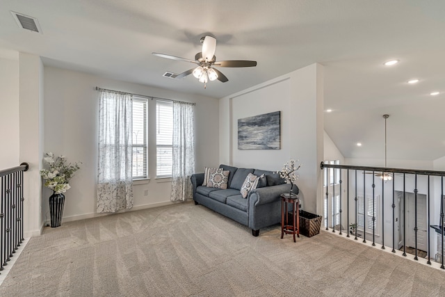 living room featuring visible vents, carpet floors, baseboards, and a ceiling fan