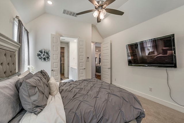 bedroom with visible vents, baseboards, lofted ceiling, carpet flooring, and ensuite bath