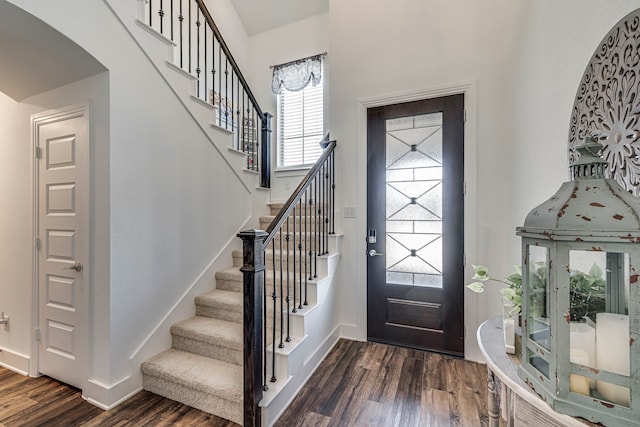 foyer featuring stairway, baseboards, and dark wood-type flooring