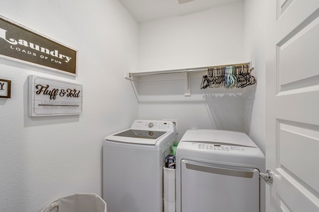 clothes washing area with visible vents, laundry area, and washing machine and clothes dryer