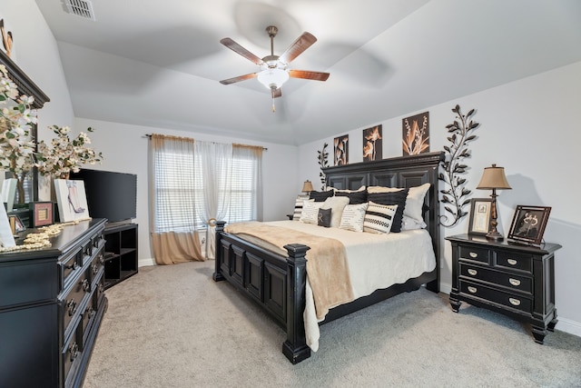 bedroom with light carpet, visible vents, a raised ceiling, and ceiling fan