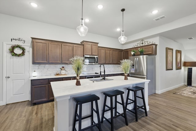 623 Woodridge Dr, Oak Point, TX 75068 - kitchen with appliances with stainless steel finishes, a sink, backsplash, light countertops, and wood finished floors