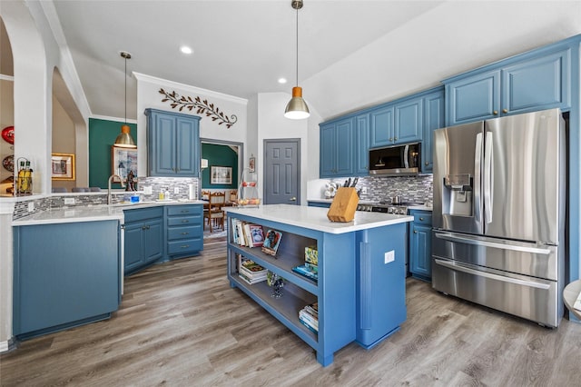 kitchen with light wood-type flooring, blue cabinetry, a kitchen island, stainless steel appliances, and light countertops