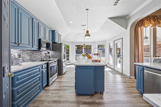 kitchen featuring visible vents, light wood-type flooring, appliances with stainless steel finishes, blue cabinets, and tasteful backsplash