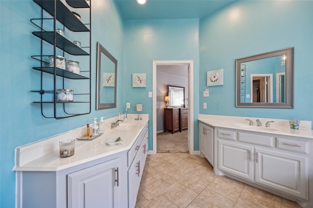 bathroom with two vanities, baseboards, and a sink