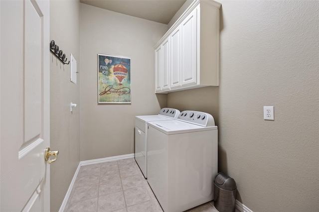 laundry area with light tile patterned floors, baseboards, cabinet space, and independent washer and dryer