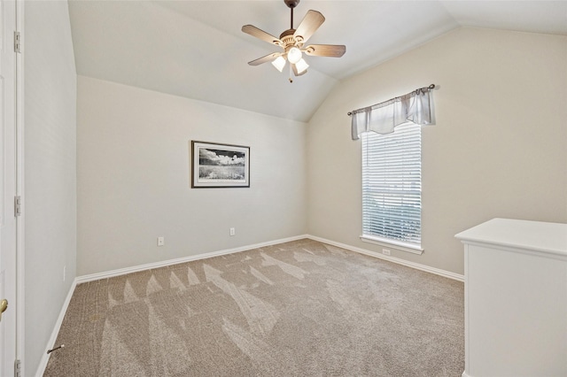 empty room featuring baseboards, lofted ceiling, carpet, and ceiling fan