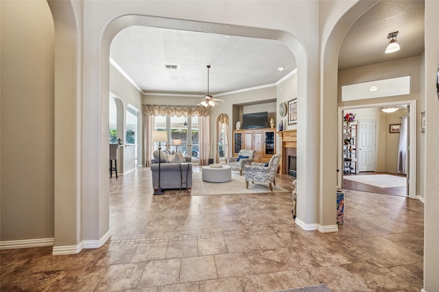 living room featuring visible vents, baseboards, and ornamental molding