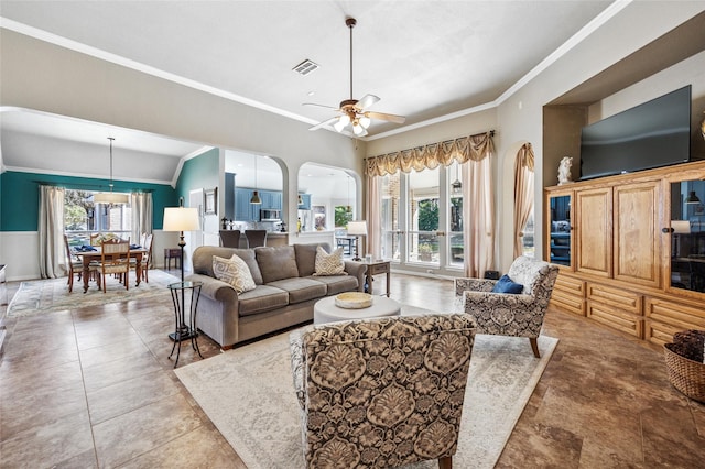 living area with crown molding, a healthy amount of sunlight, visible vents, and arched walkways