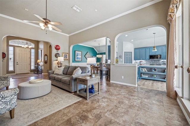 living room with visible vents, arched walkways, baseboards, and ornamental molding