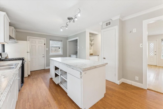 3105 Marydale Rd, Garland, TX 75041 - kitchen with a kitchen island, light wood-style flooring, ornamental molding, and white cabinetry