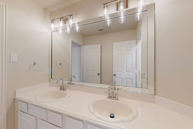 bathroom featuring double vanity, visible vents, and a sink