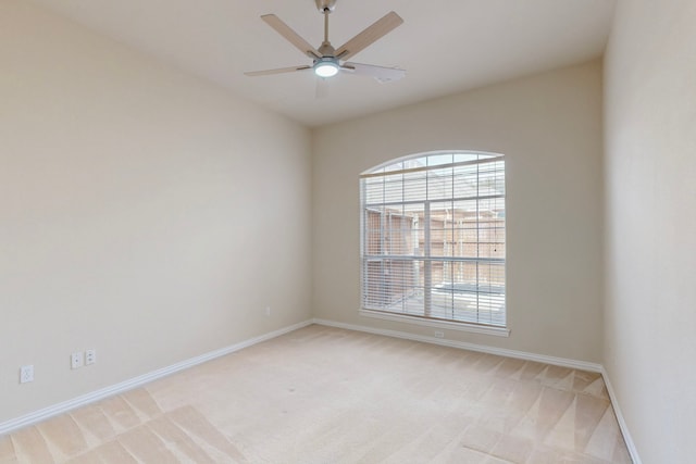 unfurnished room with a ceiling fan, light colored carpet, and baseboards