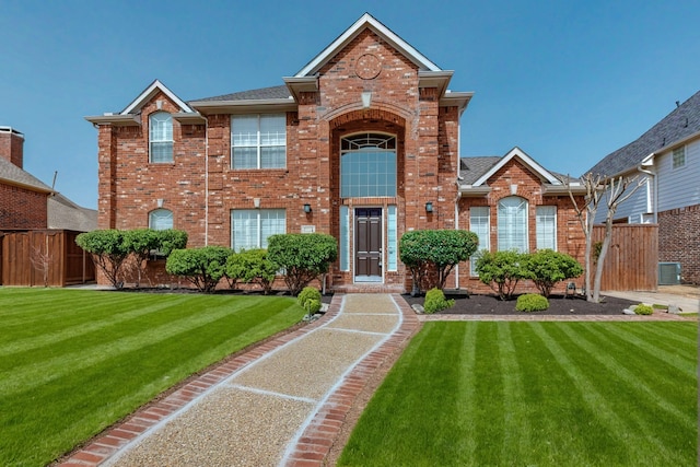 traditional home featuring brick siding, cooling unit, a front lawn, and fence