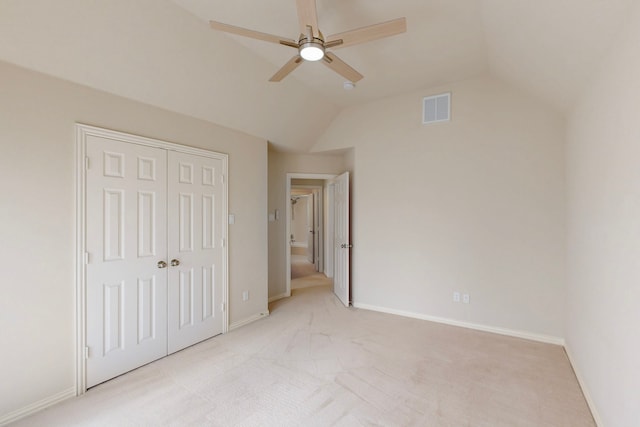 unfurnished bedroom with visible vents, light carpet, a closet, baseboards, and vaulted ceiling