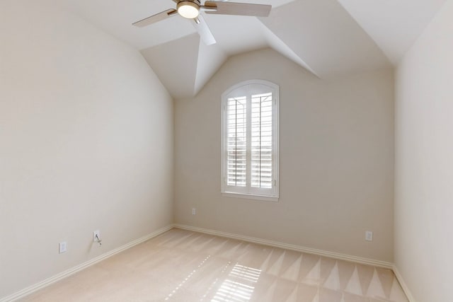 empty room with ceiling fan, lofted ceiling, baseboards, and light carpet